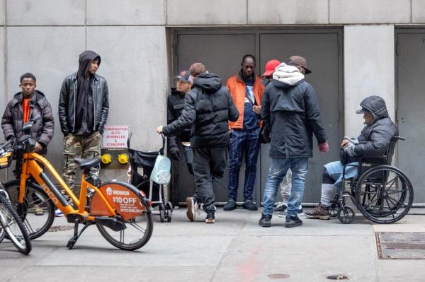 Photo shows people on foot and bikes behind the migrant shelter.