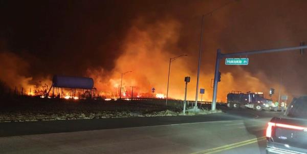 This photo provided by County of Maui shows fire and smoke filling the sky from wildfires on the intersection at Hokiokio Place and Lahaina Bypass in Maui, Hawaii on Tuesday, Aug. 8, 2023. 