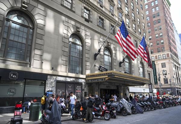 Migrants line up outside Roosevelt Hotel in Midtown Manhattan on Tuesday, August 1, 2023.
