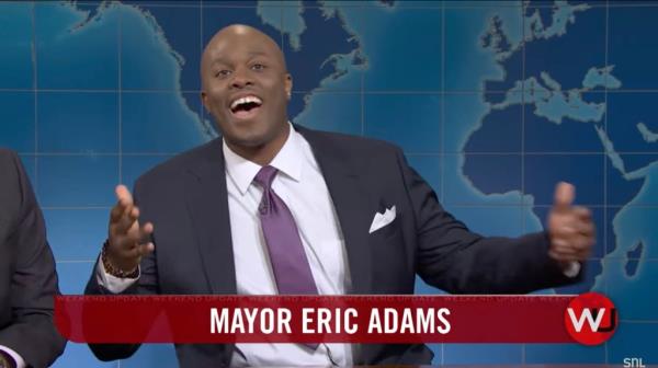 New York City Mayor Eric Adams in a suit and tie on SNL's Weekend Update, questio<em></em>ning Michael Che a<em></em>bout his perceived guilt