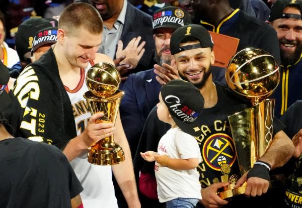 Nuggets center Nikola Jokic (15) celebrates with the Bill Russell NBA Finals MVP Award