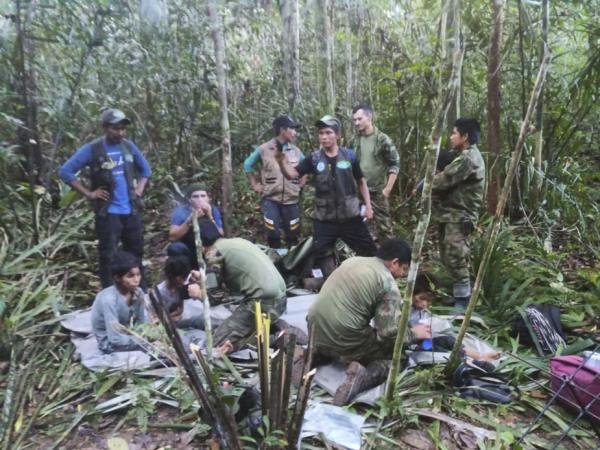 In this photo released by Colombia's Armed Forces Press Office, soldiers and Indigenous men tend to the four Indigenous brothers who were missing after a deadly plane crash, in the Solano jungle, Caqueta state, Colombia, Friday, June 9, 2023. 