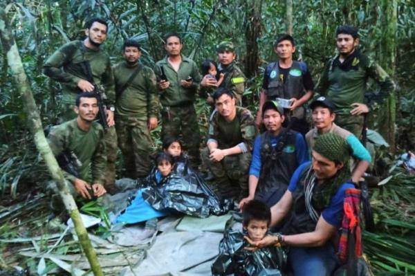 Soldiers and Indigenous men pose for a photo with the four Indigenous brothers who were missing after a deadly plane crash, in the Solano jungle, Caqueta state, Colombia, Friday, June 9, 2023
