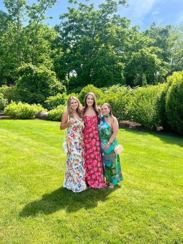 Three women in colorfully patterned dresses standing outdoors