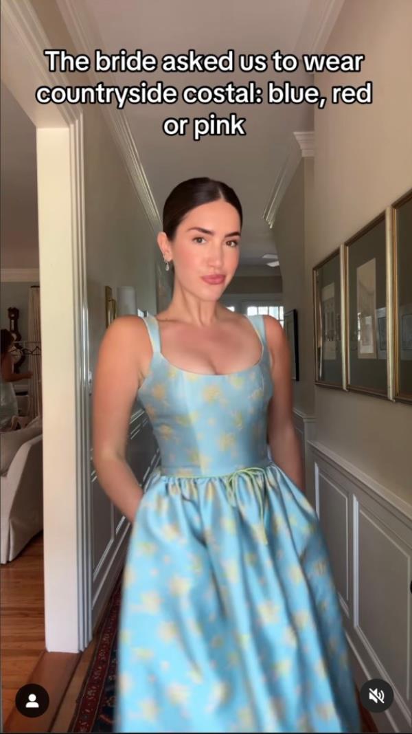 Woman in a blue dress standing in a hallway