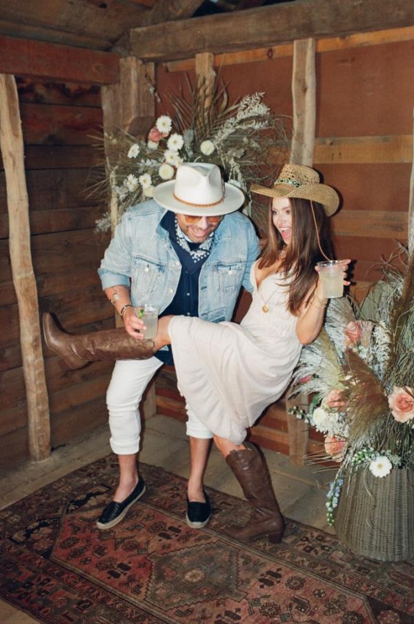Woman in cowboy hat kicking up her leg next to a man leaning forward