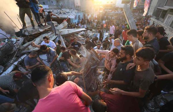 Numerous civilians survey the rubble od damaged buildings following a strike in Khan Yunis in southern Gaza on Saturday.