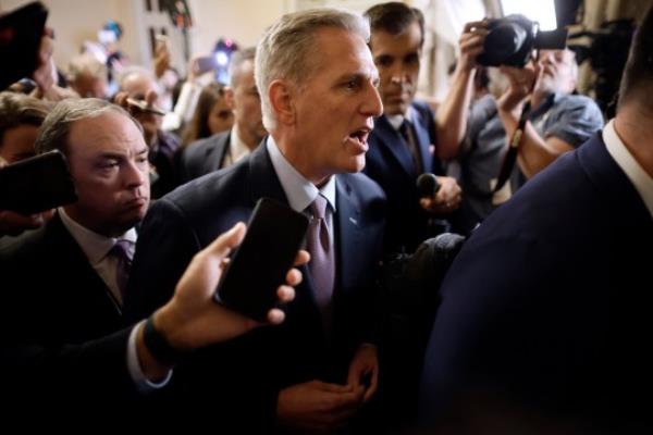 Kevin McCarthy is surrounded by staff, security and journalists as he walks to the House Chamber ahead of the vote