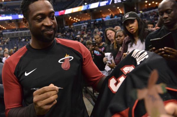 Miami Heat guard Dwyane Wade signs autographs before an NBA basketball game against the Memphis Grizzlies on Friday, Dec. 14, 2018, in Memphis, Tenn.