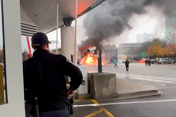 A Customs and Border Protection officer watches the vehicle burn.