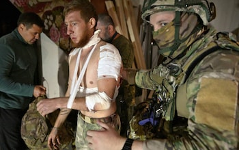 Medics help an injured man in a field hospital in Russia's Kursk region