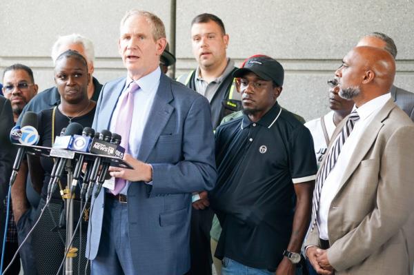 MTA CEO Jano Lieber, (right)  Anthony Nelson outside, upon leaving courtroom after final of two hearings at Bronx Criminal Courthouse this morning.  His right arm is in a sling under his shirt.  He was assaulted by a perp Alexander Wright, age 49 previously arrested 41 times.