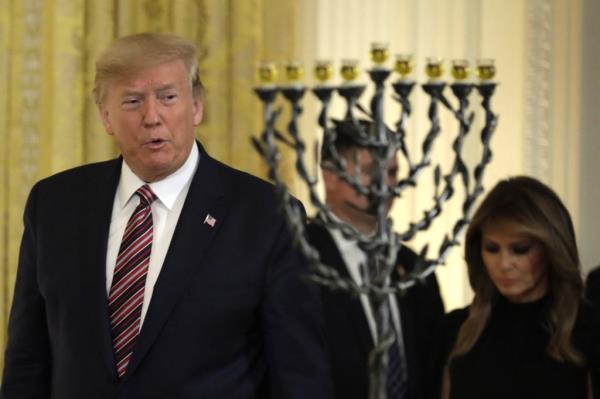 Do<em></em>nald Trump glances at a menorah at the December 2019 event.