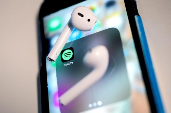 Airpods on a smartphone with Spotify app displaying