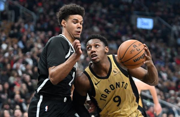 Cam Johnson (L.) guards RJ Barrett during the Nets' loss to the Raptors on Feb. 22, 2024. 