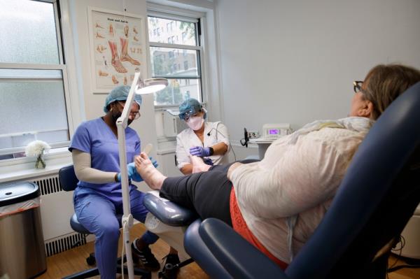 Marcela Correa performs medical pedicures on patient Heidi Hlwati with fellow nail technician Kymani.