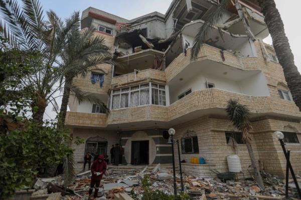 People inspect the damage to their homes in an apartment building in Rafah that was hit with shells following the strikes on Saturday.